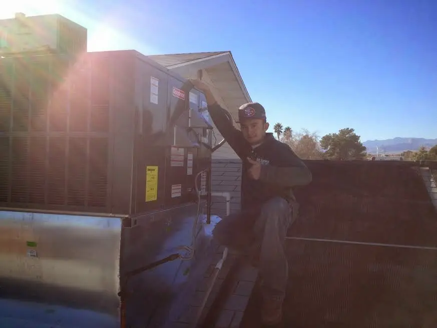HVAC technician performing Air Duct Cleaning on a rooftop unit in Kennett Square